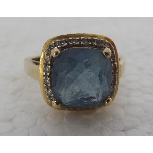 429 - A 9ct gold ring, set with a central blue topaz, surrounded by diamonds 