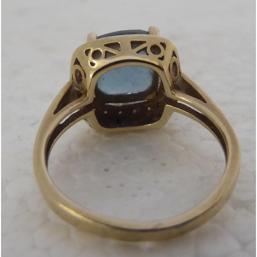 429 - A 9ct gold ring, set with a central blue topaz, surrounded by diamonds 