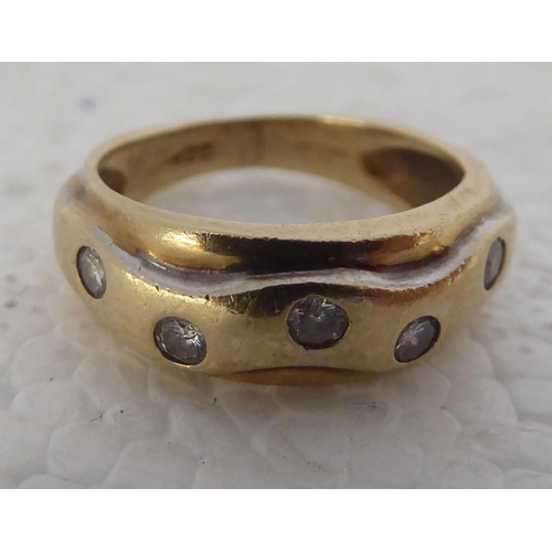 432 - A 9ct gold ring, set with six diamonds, decorated in a wavy pattern 