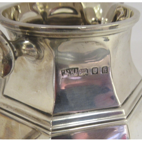 53 - A silver cream jug of bulbous octagonal form with a S-scrolled handle  London 1924 