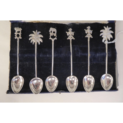 74 - Twelve Indian silver coloured metal spoons, each terminal with an ornamental finial 