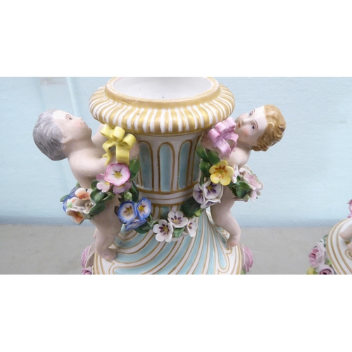 83 - A pair of late 19thC Continental encrusted porcelain pedestal vases and covers, decorated in bright ... 