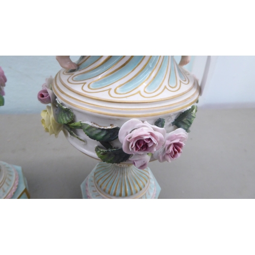 83 - A pair of late 19thC Continental encrusted porcelain pedestal vases and covers, decorated in bright ... 