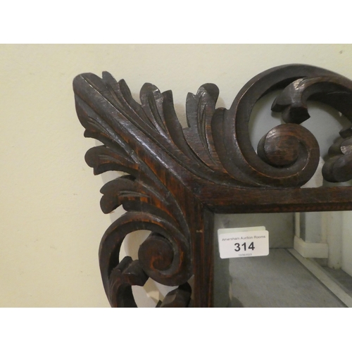 314 - A 1930s mirror, set in a C-scrolled and foliate carved frame  24