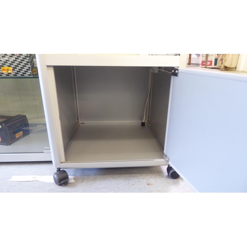 115 - A modern, fully glazed and shelved retailer's display cabinet with a single door, on casters  75