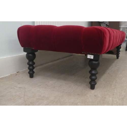 12 - A modern footstool, part button upholstered in red fabric, over a stained wooden frame