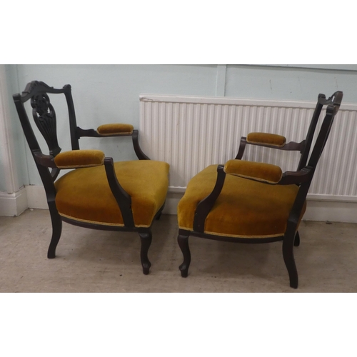 18 - A pair of Edwardian mahogany framed open arm salon chairs, upholstered in old gold fabric, raised on... 