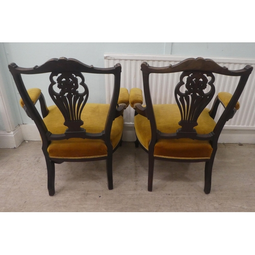 18 - A pair of Edwardian mahogany framed open arm salon chairs, upholstered in old gold fabric, raised on... 