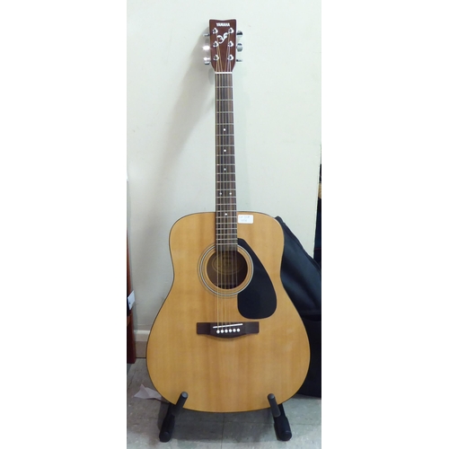 328 - A Yamaha model no. F310 acoustic guitar  cased with a stand 