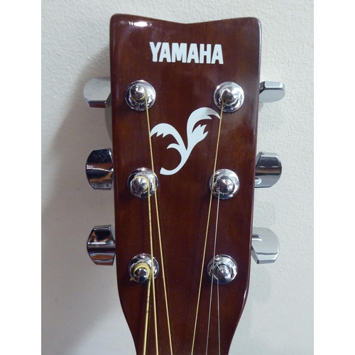 328 - A Yamaha model no. F310 acoustic guitar  cased with a stand 