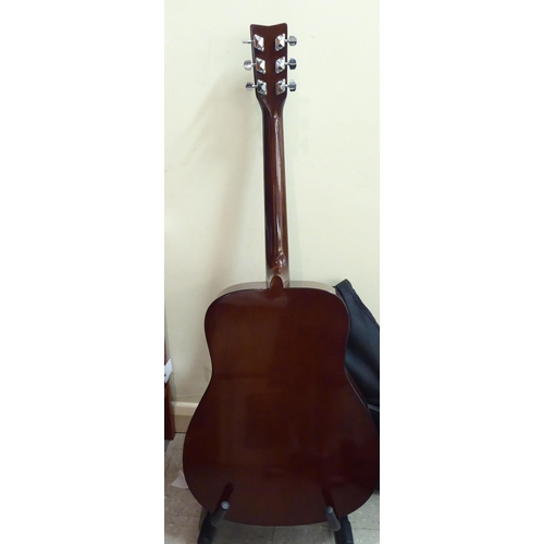 328 - A Yamaha model no. F310 acoustic guitar  cased with a stand 