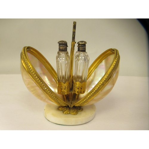 40 - A gilt metal and shell mounted perfume carrier, opening to reveal a pair of cut glass bottles, on an... 