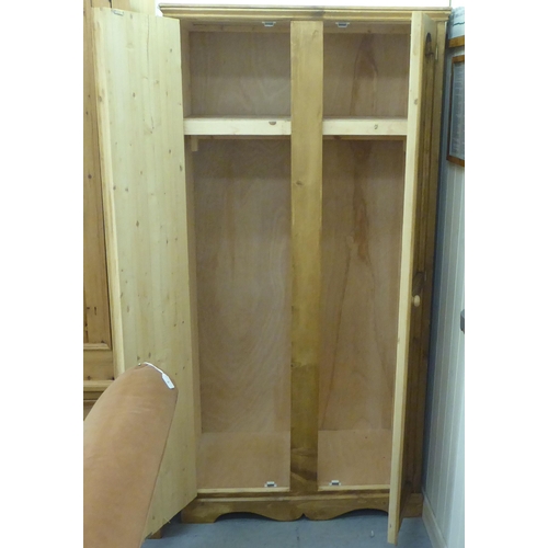 43 - A modern pine effect two door wardrobe, on a bracket plinth  42