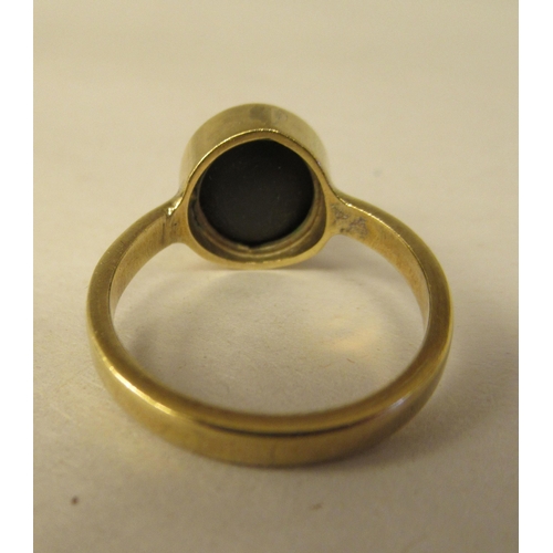 64 - A gold coloured metal ring, set with a star sapphire  