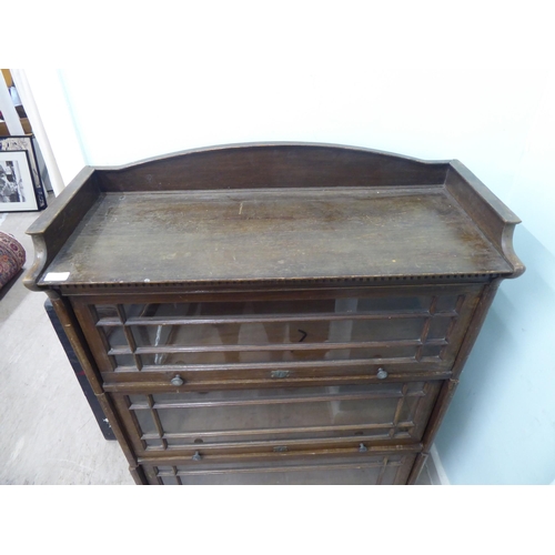 332 - An early 20thC oak three section Globe Wernicke style bookcase, on a plinth  52h  35