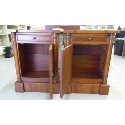 118 - A pair of modern yewwood bedside cupboards, each with a single drawer, over an enclosed shelf, raise... 