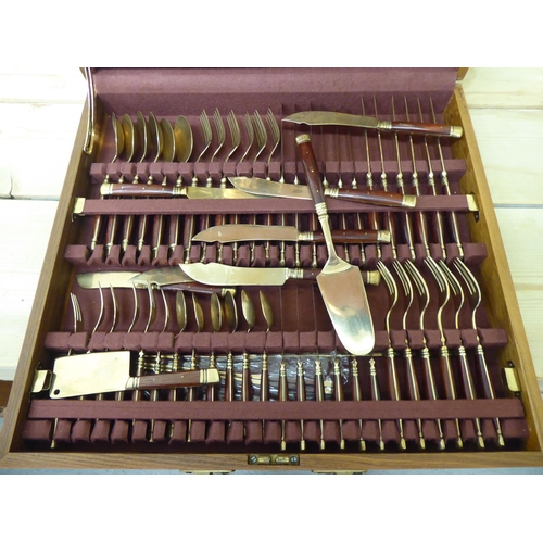 42 - An Indonesian gilt brass canteen with rivetted hardwood handles, in a fitted case&nbsp;