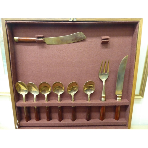 42 - An Indonesian gilt brass canteen with rivetted hardwood handles, in a fitted case&nbsp;