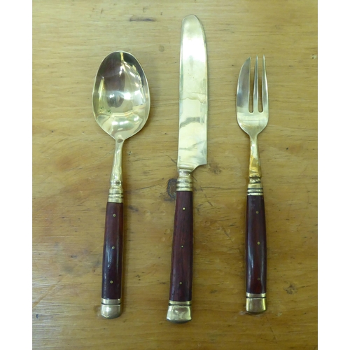 42 - An Indonesian gilt brass canteen with rivetted hardwood handles, in a fitted case&nbsp;