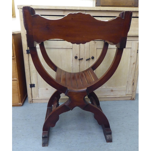 68 - A 20thC Savonarola design lacquered mahogany framed chair with C-scrolled, foliate and mask carved o... 
