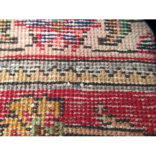 69 - A Persian carpet, decorated with flora and foliate designs, on a mainly red ground with a dark blue ... 