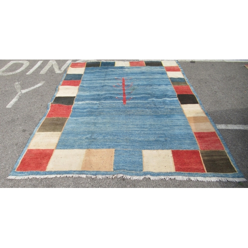 70 - A Gabbeh Shiraz woollen carpet, decorated in bright colours, on a pale ground, bordered by box desig... 