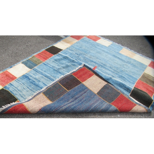 70 - A Gabbeh Shiraz woollen carpet, decorated in bright colours, on a pale ground, bordered by box desig... 