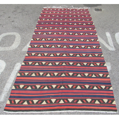 71 - A Kelim rug, decorated with repeating bands of colours and stylised design, on a multi-coloured grou... 