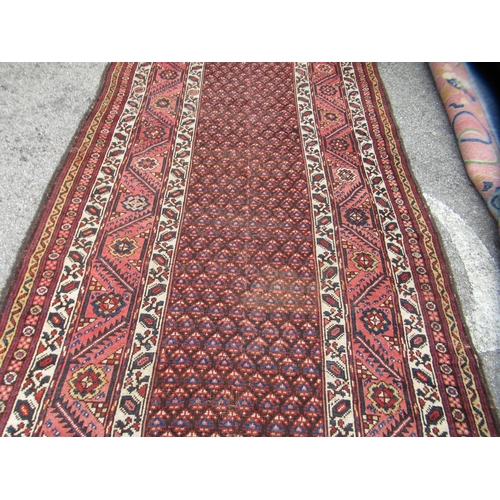 78 - A Persian runner, decorated with a central panel, bordered by zig-zag and foliate designs, on a main... 