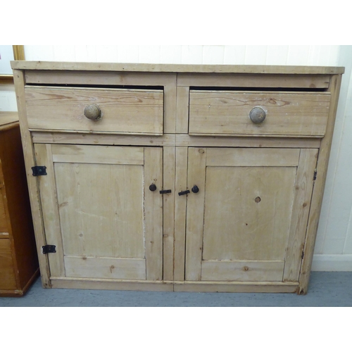 79 - A late 19thC bleached pine side cabinet with two drawers, over two panelled doors, on a plinth&nbsp;... 