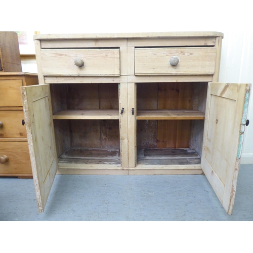 79 - A late 19thC bleached pine side cabinet with two drawers, over two panelled doors, on a plinth&nbsp;... 