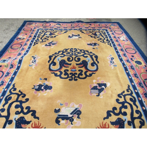 83 - A Chinese carpet, decorated in bright pastel tones within a dark blue border, a dragon and other des... 
