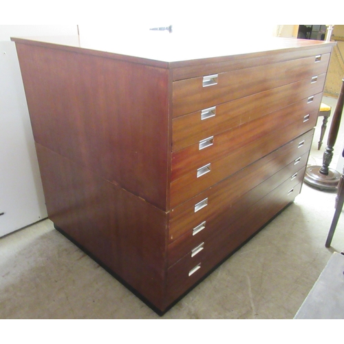 88 - A mid 20thC teak finished two part plan chest, comprising eight equal drawers with recessed metal ha... 