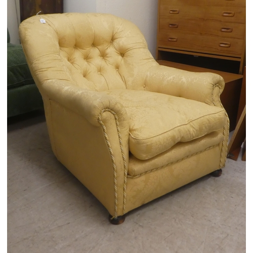 91 - An early 20thC buttoned gold coloured and part buttoned floral patterned and cushion upholstered low... 