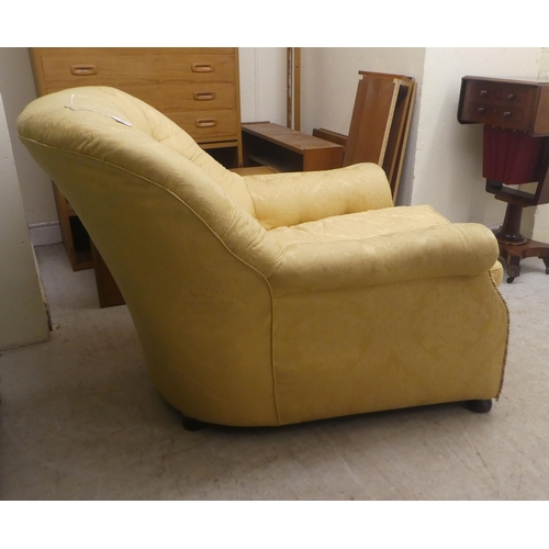 91 - An early 20thC buttoned gold coloured and part buttoned floral patterned and cushion upholstered low... 