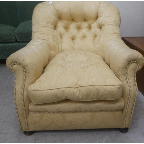 91 - An early 20thC buttoned gold coloured and part buttoned floral patterned and cushion upholstered low... 