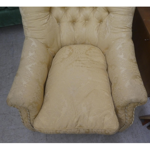 91 - An early 20thC buttoned gold coloured and part buttoned floral patterned and cushion upholstered low... 