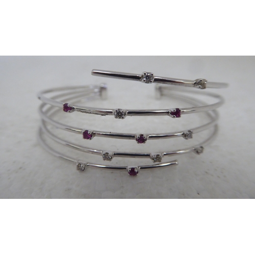 94 - An 18ct white gold multi-strand open bangle, set with diamonds and pink sapphires&nbsp;