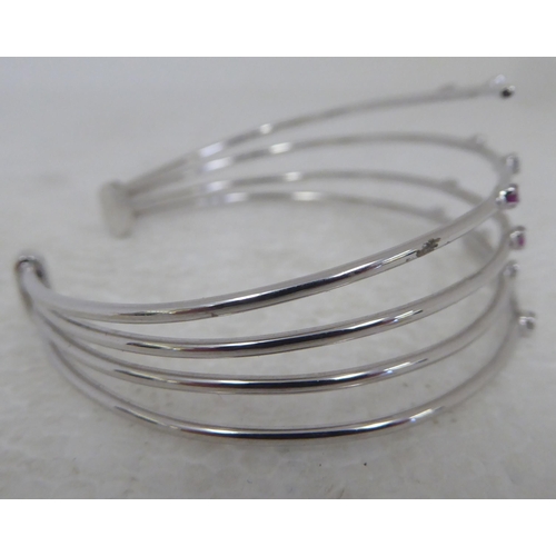 94 - An 18ct white gold multi-strand open bangle, set with diamonds and pink sapphires&nbsp;