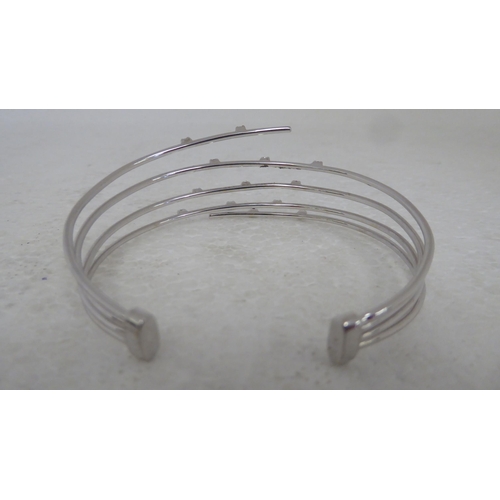 94 - An 18ct white gold multi-strand open bangle, set with diamonds and pink sapphires&nbsp;