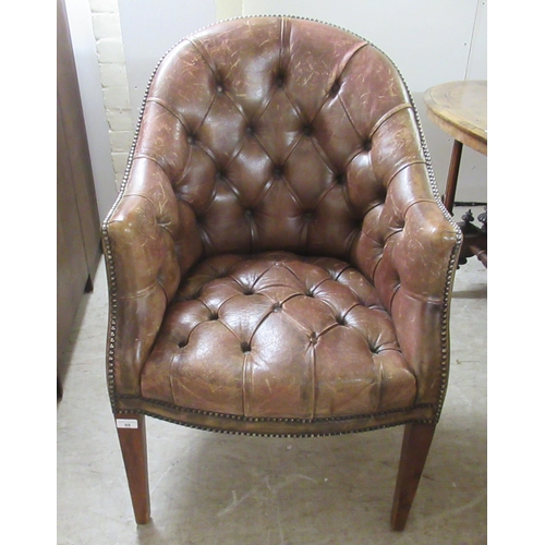 98 - An early 19thC style tub design study chair with a studded and buttoned, mid brown hide back and sea... 