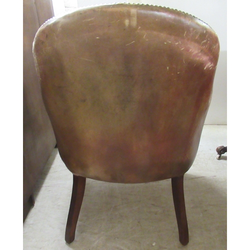 98 - An early 19thC style tub design study chair with a studded and buttoned, mid brown hide back and sea... 