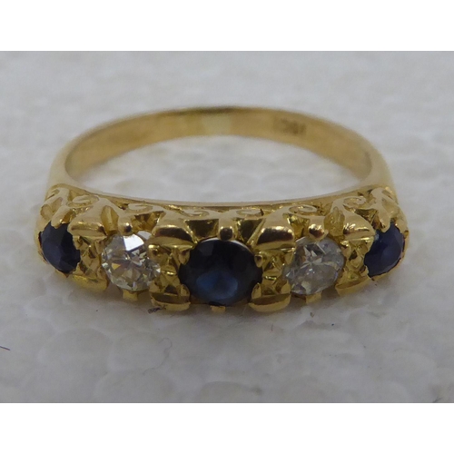 99 - A gold coloured metal ring&nbsp; stamped 18ct, set with alternating sapphires and diamonds&nbsp;