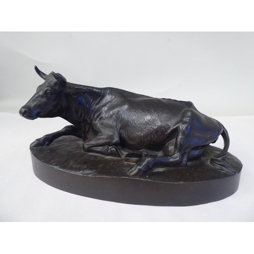 10 - A cast and patinated bronze model, a recumbent cow, on an oval base  bears an indistinctly impr... 