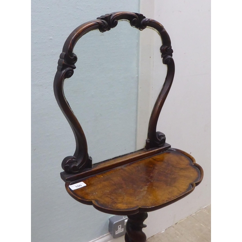 100 - A Victorian walnut dressing room pedestal table with a carved upstand glazed frame, on a scalloped e... 