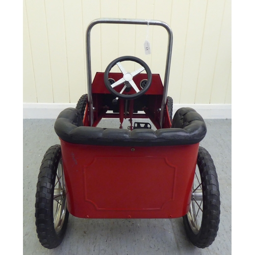 11 - A painted model pedal car, in the manner of a veteran vehicle with red livery and spoked rubber whee... 