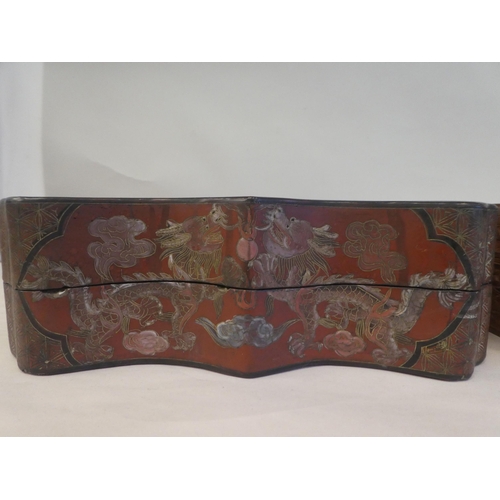 131 - A Chinese lacquered and painted papier mache serpentine outlined box and cover, featuring dragons an... 