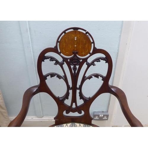 133 - An Art Nouveau style Jones & Higgins mahogany framed chair with an open foliate scroll carved an... 