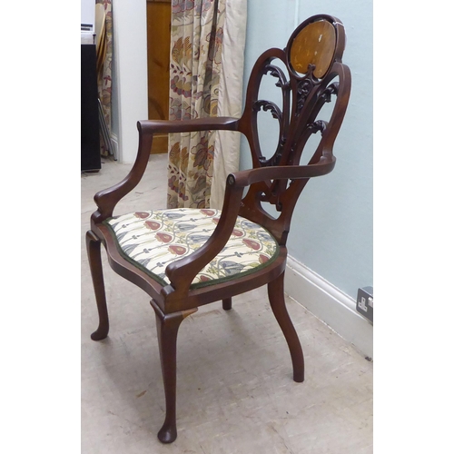 133 - An Art Nouveau style Jones & Higgins mahogany framed chair with an open foliate scroll carved an... 