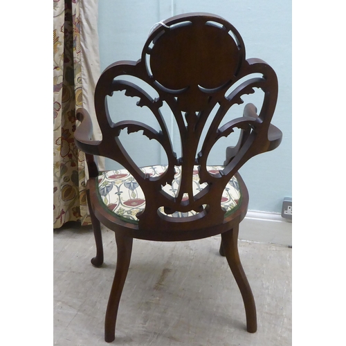 133 - An Art Nouveau style Jones & Higgins mahogany framed chair with an open foliate scroll carved an... 